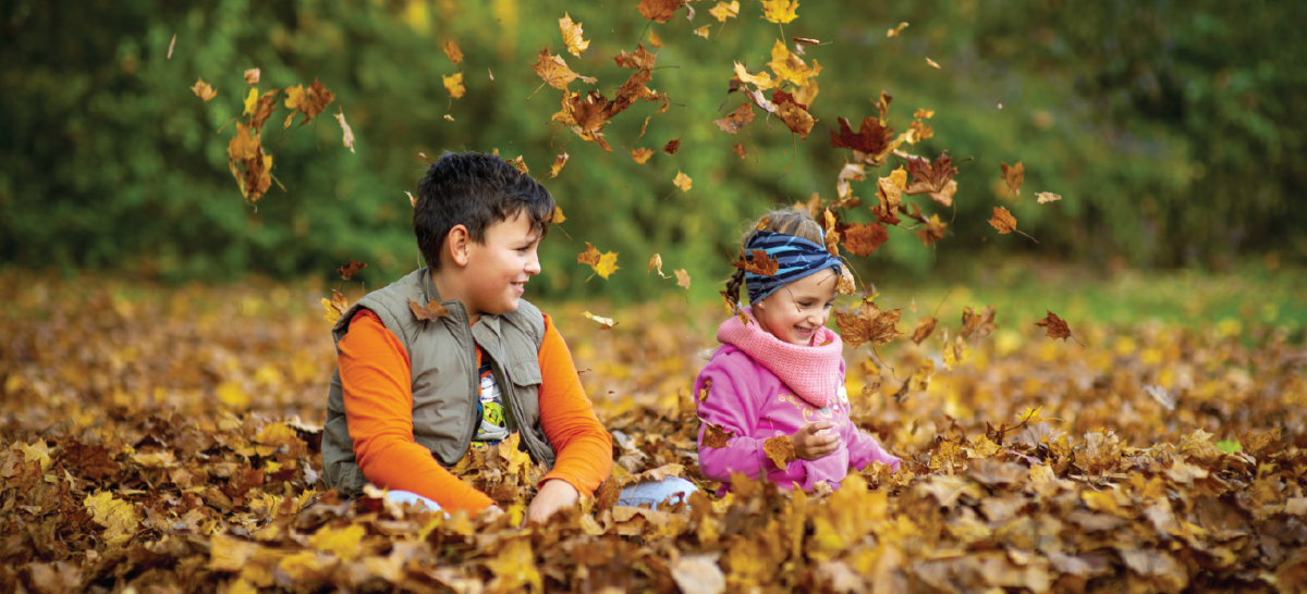 Children playing in fall leaves.